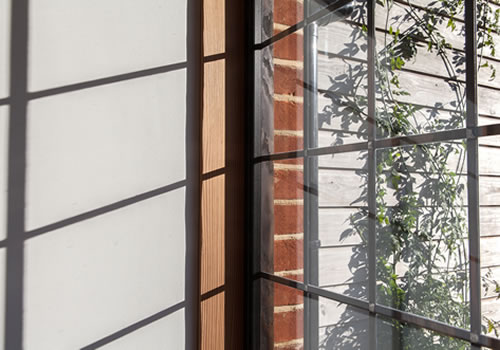 Shadows cast by the slim metal window bars inside Beech Cottage