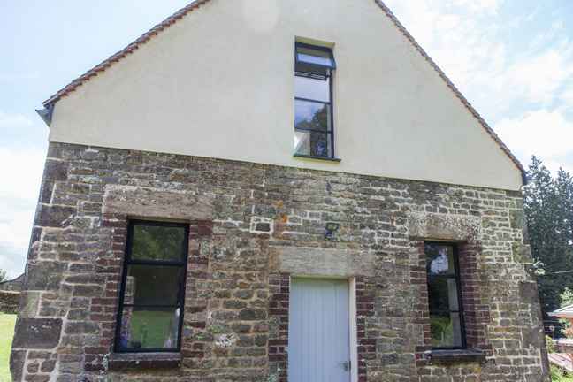 Steel windows installed in the renovated outbuilding
